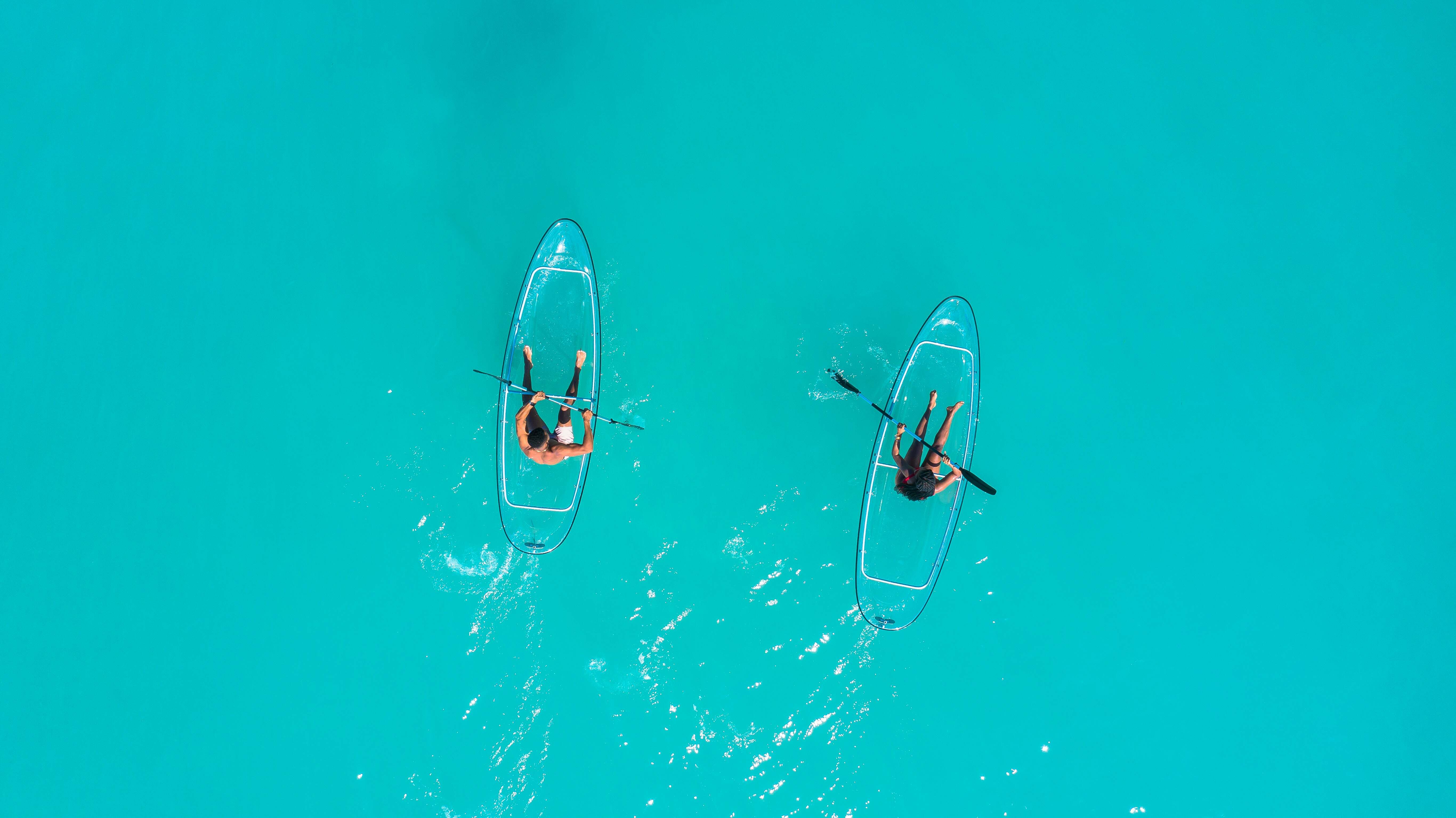 two people in transparent kayaks