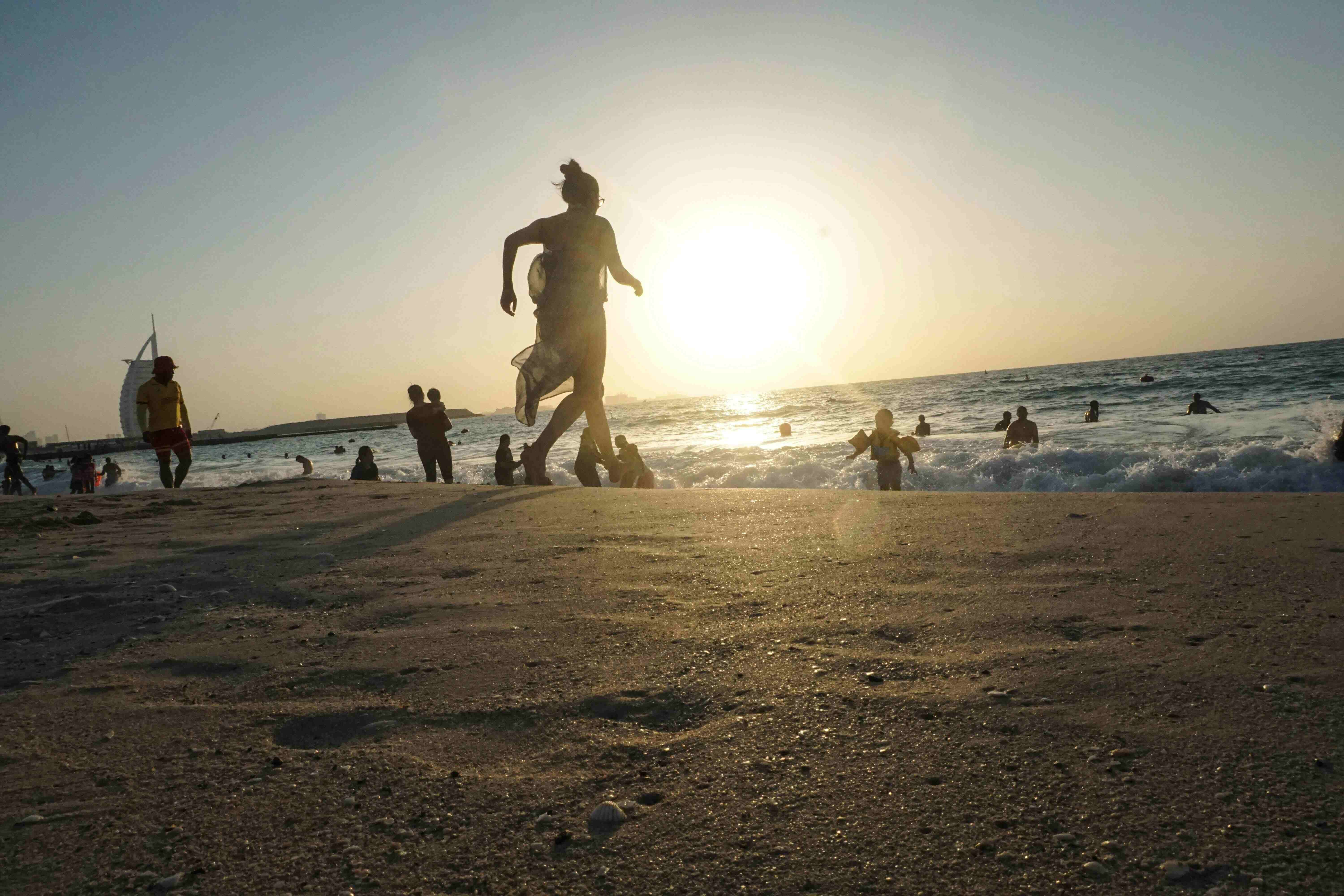 beach in dubai with people running around